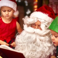 Mikołaj i 2 dzieci przeglądaja książkę.