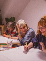 Grupa osób podczas zajęć plastycznych.