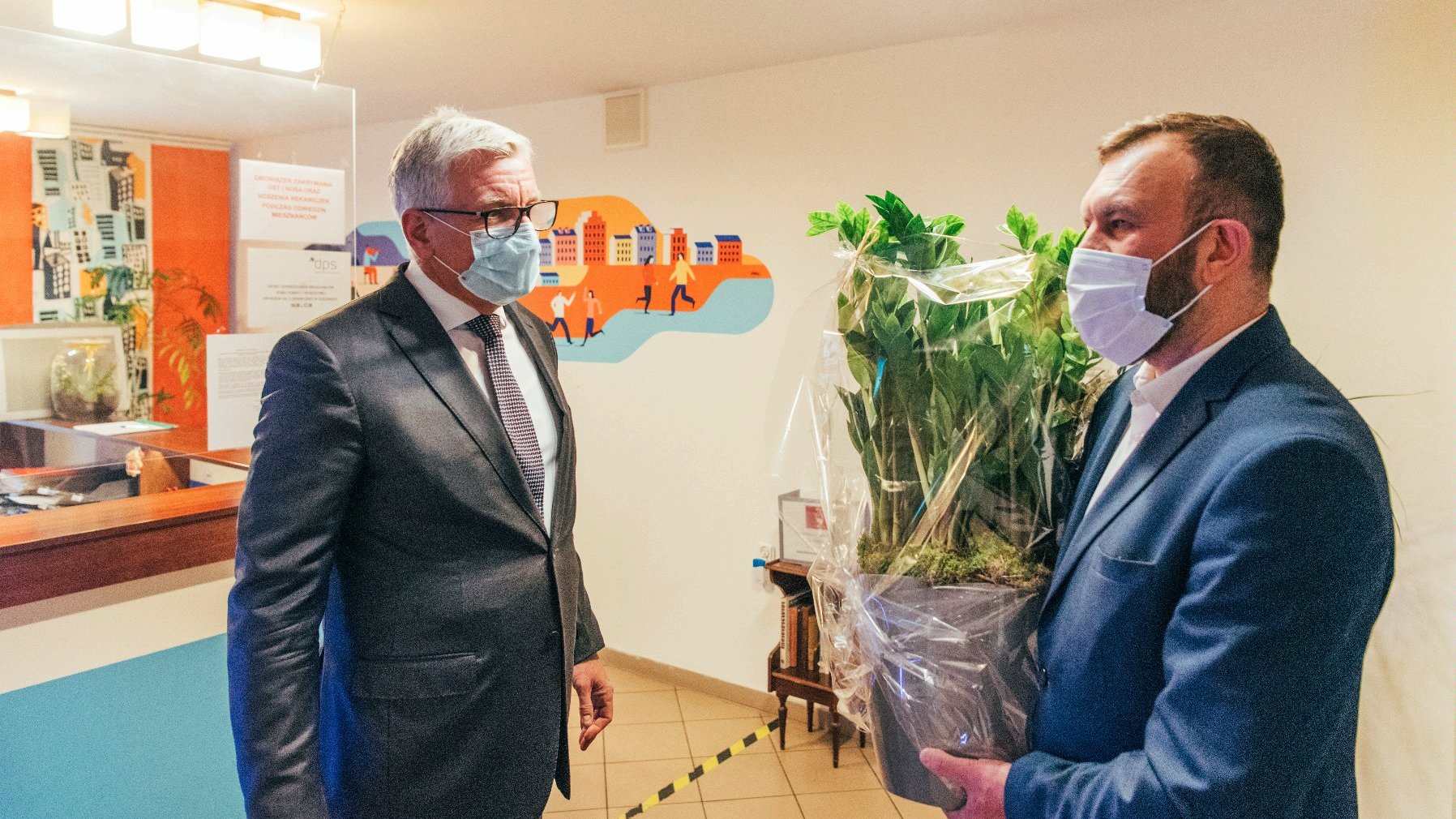 Na zdjęciu Jacek Jaśkowiak, prezydent Poznania, przekazujący roślinę dyrektorowi DPS