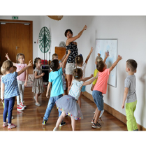 Grupa dzieci i animatorka w bawialni