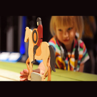 Figurka przedstawiająca rycerza na koniu, w tle rozmazana twarz dziecka.