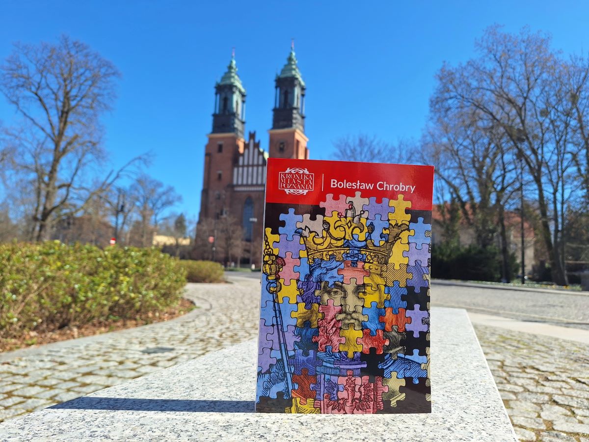 Tom Kroniki Miasta Poznania poświęcony Bolesławowi Chrobremu, wydawca: Wydawnictwo Miejskie Posnania na tle katedry w Poznaniu - książka z wizerunkiem Bolesława Chrobrego w kolorowej grafice stylizowanej na puzzle