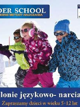 Baner: 4 dzieci w kolorowych kombinezonach narciarskich biegnie po śniegu.