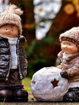 Baner: Dwie giniane figurki w kurtkach i czapkach w parku. Jeden pcha kulę.