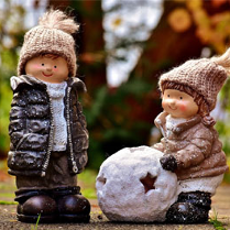 Baner: Dwie giniane figurki w kurtkach i czapkach w parku. Jeden pcha kulę.