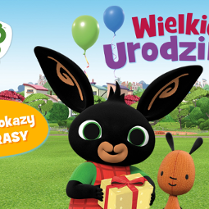 Grafika z czarnym króliczkiem Bingiem i jego przyjacielem misiem. W tle zielona łąka z placem zabaw i domy.