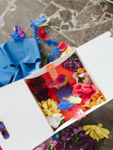 Kolorowe kwity , wstążki i na blacie i w białym pudełku.