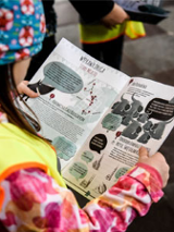 Dziecko patrzy na strony Przewodnika po Trakcie Królewsko-Cesarskim dla dzieci.