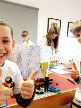 Uśmiechnięte dzieci. Na stole klocki lego.