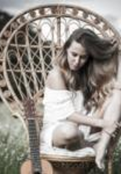 Na wiklinowym fotelu siedzi Ola Jas.