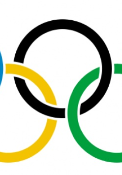 Pięć kół olimpijskich nachodzących na siebie. Trzy koła w górnym rzędzie (niebieskie, czarne i czerwone), dwa koła w dolnym rzędzie (żółte i zielone).