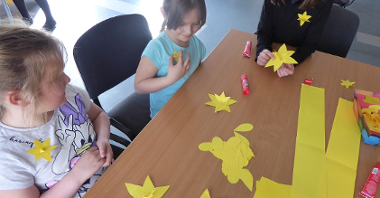 zdjęcie przedstawia dzieci tworzące papierowe żonkile