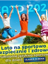 Troje dzieci: chłopiec i 2 dziewczynki w podskoku z rękoma w górze, na tle krzaków i trawy. Na dole napis: "Lato na sportowo bezpiecznie i zdrowo. Półkolonie językowo - sportowe Leader School"