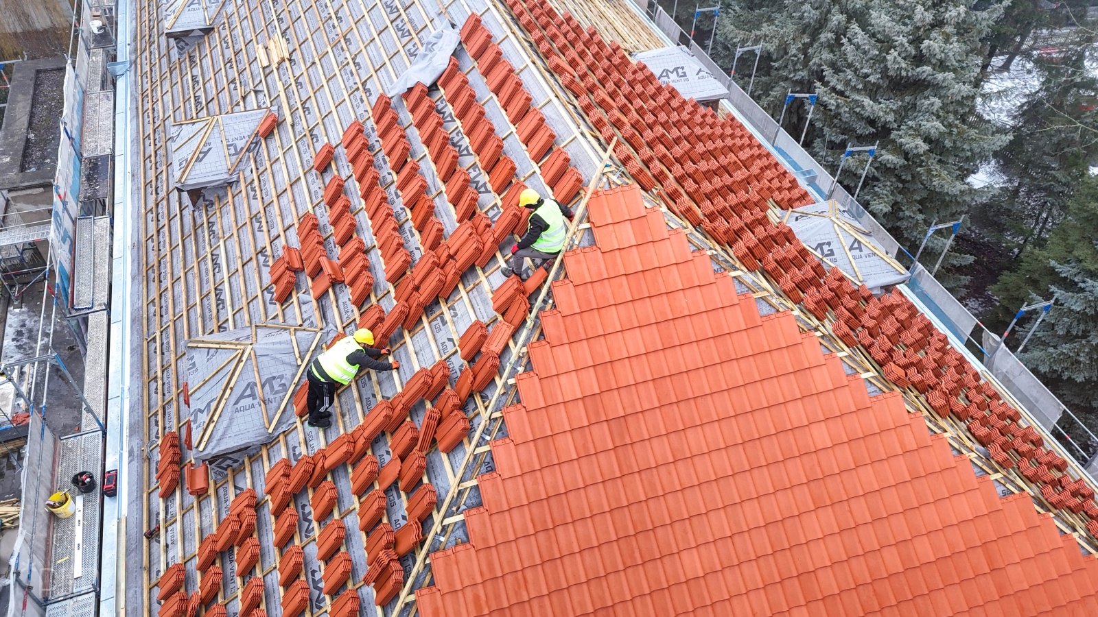 Układanie nowej dachówki na dachu przedszkola