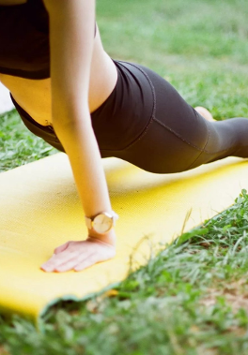 Kobieta uprawiająca jogę na trawie.