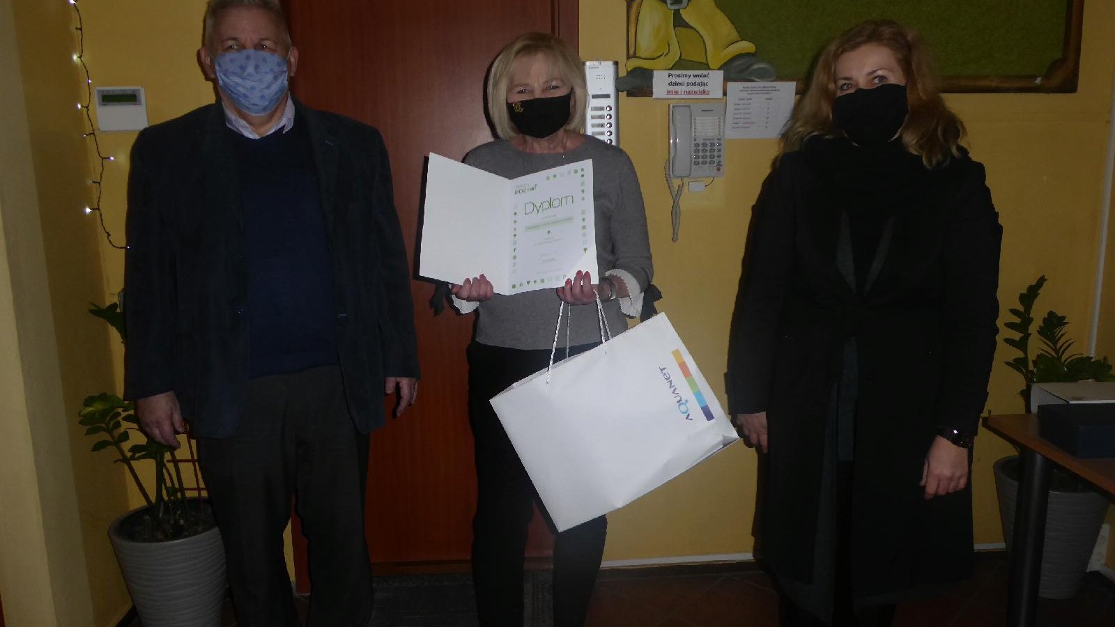 Zdjęcie przedstawia osoby trzymające dyplom i statuetkę. - grafika artykułu