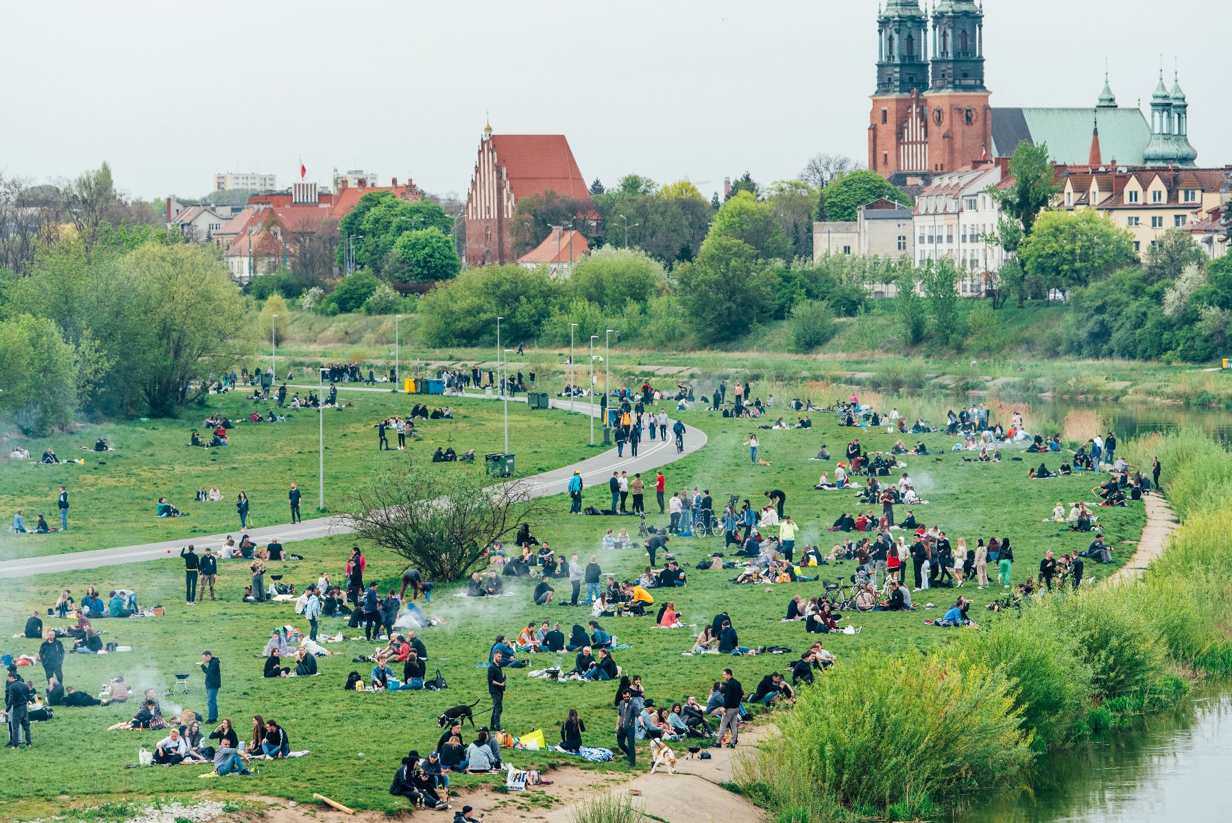 Poznaniacy często wypoczywają i grillują nad rzeką Zdjęcie przedstawia tłum ludzi wypowczywających nad rzeką.