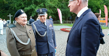 Po lewej dwaj starsi mężczyźni w mundurach, po prawej Jacek Jaśkowiak, prezydent Poznania