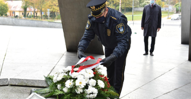 Na zdjęciu Jacek Jaśkowiak, prezydent Poznania i strażnik miejski składajają kwiaty.