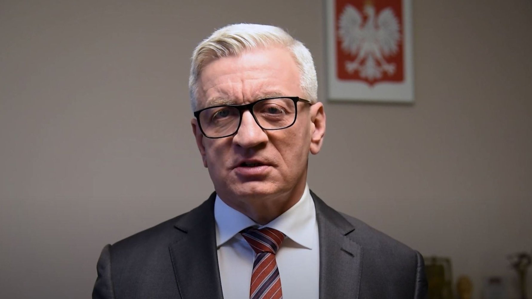 Kadr z filmu, Jacek Jaśkowiak, prezydent Poznania w swoim gabinecie, w tle godło Polski - grafika artykułu