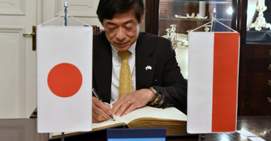 Ambasador Japonii wpisuje się do księgi pamiątkowej