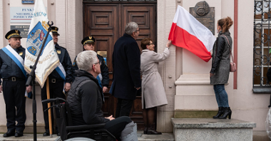 Przed budynkiem urzędu miasta, dwie kobiety odsłaniają tablicę, przyglądają się temu Jacek Jaśkowiak i Grzegorz Ganowicz