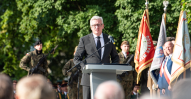 Na zdjęciu Jacek Jaśkowiak, prezydent Poznania, przy mikrofonie, w tle poczet sztandarowy