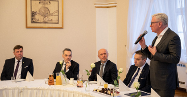 Na zdjęciu prezydent Poznania z mikrofonem w ręku, przy stole siedzą goście