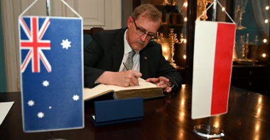 Na zdjęciu ambasador Australii wpisujący się do księgi pamiątkowej
