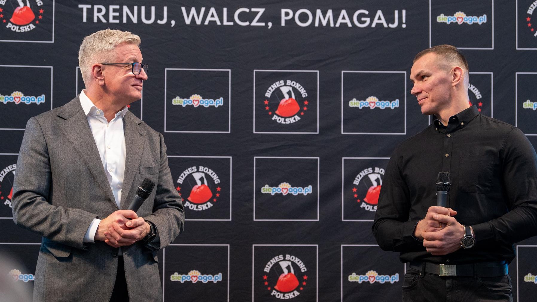 Na zdjęciu Jacek Jaśkowiak i Mateusz Masternak stoją obok siebie podczas konferencji prasowej