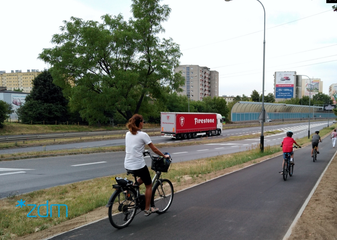 rowerzysci i piesi na wyremontowanej trasie, dalej tir i drzewo - grafika artykułu