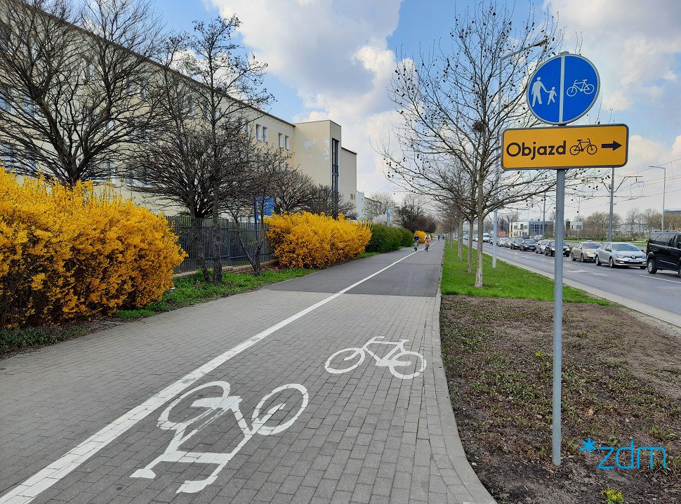 Galeria zdjęć inwestycji rowerowych z poprzednich lat. Droga rowerowa, obok chodnik. Po obu stronach zieleń a dalej z jednej strony: blok, a z drugiej: i ulica. - grafika artykułu