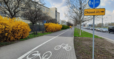Galeria zdjęć inwestycji rowerowych z poprzednich lat. Droga rowerowa, obok chodnik. Po obu stronach zieleń a dalej z jednej strony: blok, a z drugiej: i ulica.