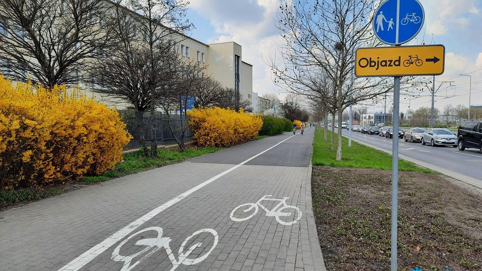 Galeria zdjęć inwestycji rowerowych z poprzednich lat. Droga rowerowa, obok chodnik. Po obu stronach zieleń a dalej z jednej strony: blok, a z drugiej: i ulica. - grafika artykułu