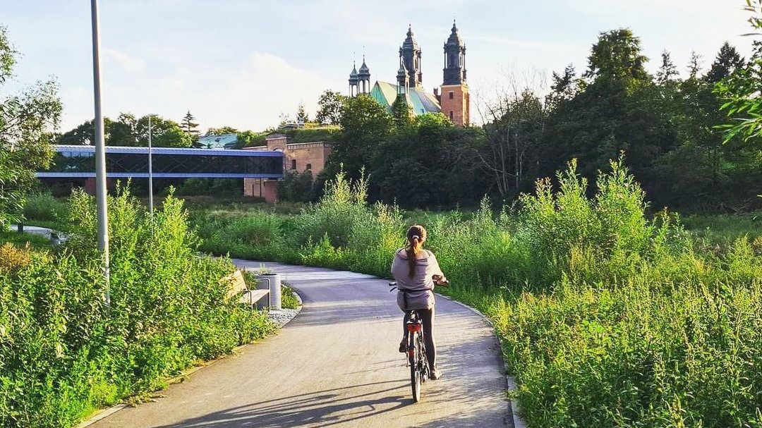 Rowerzystka na Wartostradzie koło Bramy Poznania i Cybiny. W tel widać katedrę - grafika artykułu