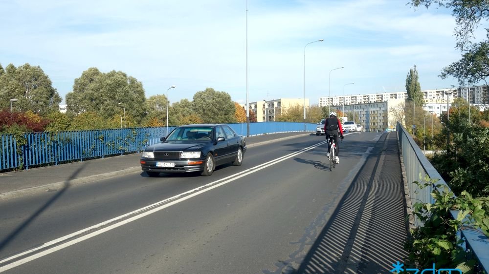 Wiadukt na ul. Kurlandzkiej. Na wiadukcie rowerzysta i samochód. - grafika artykułu