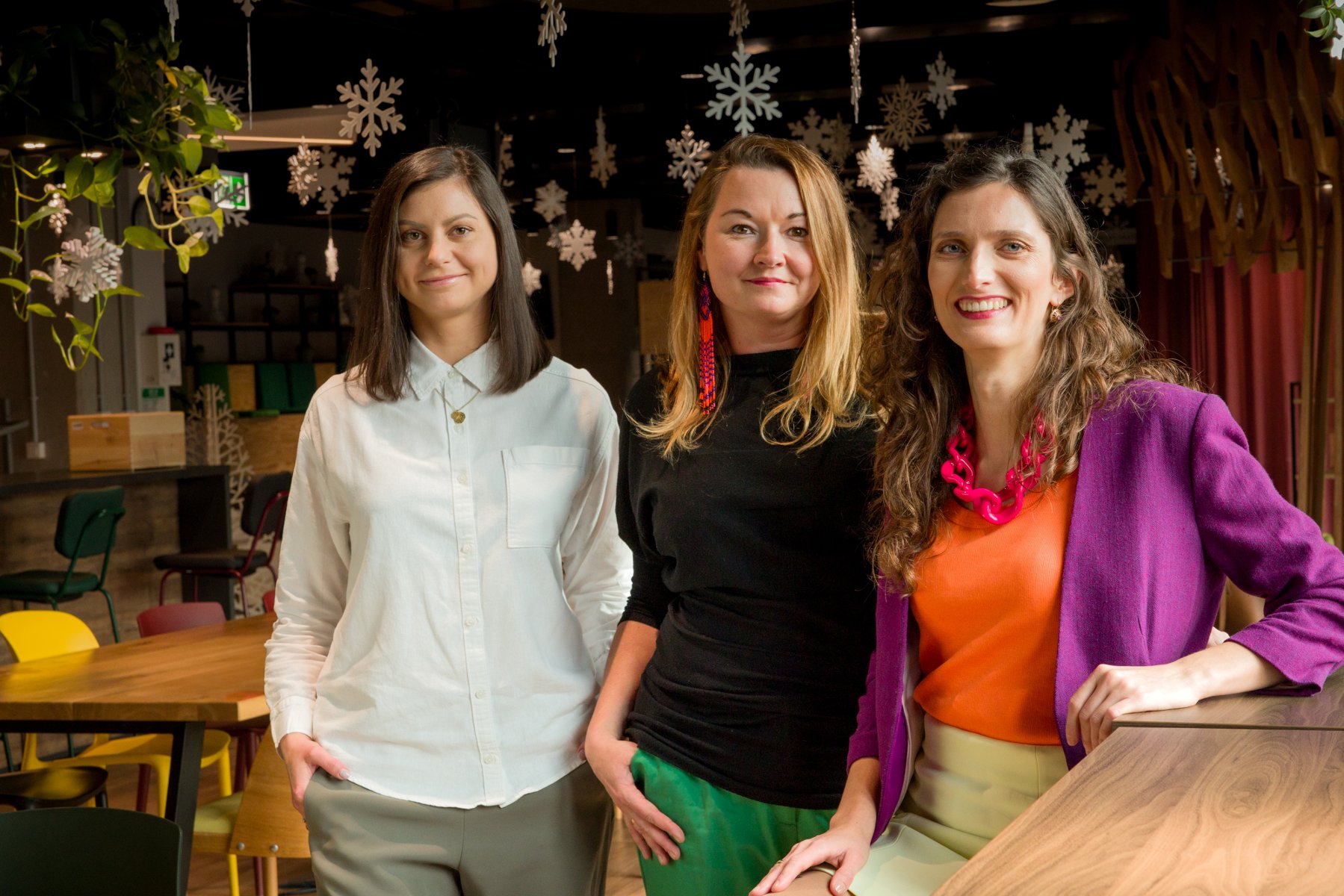 Three smiling women pose together in a photo. - grafika artykułu