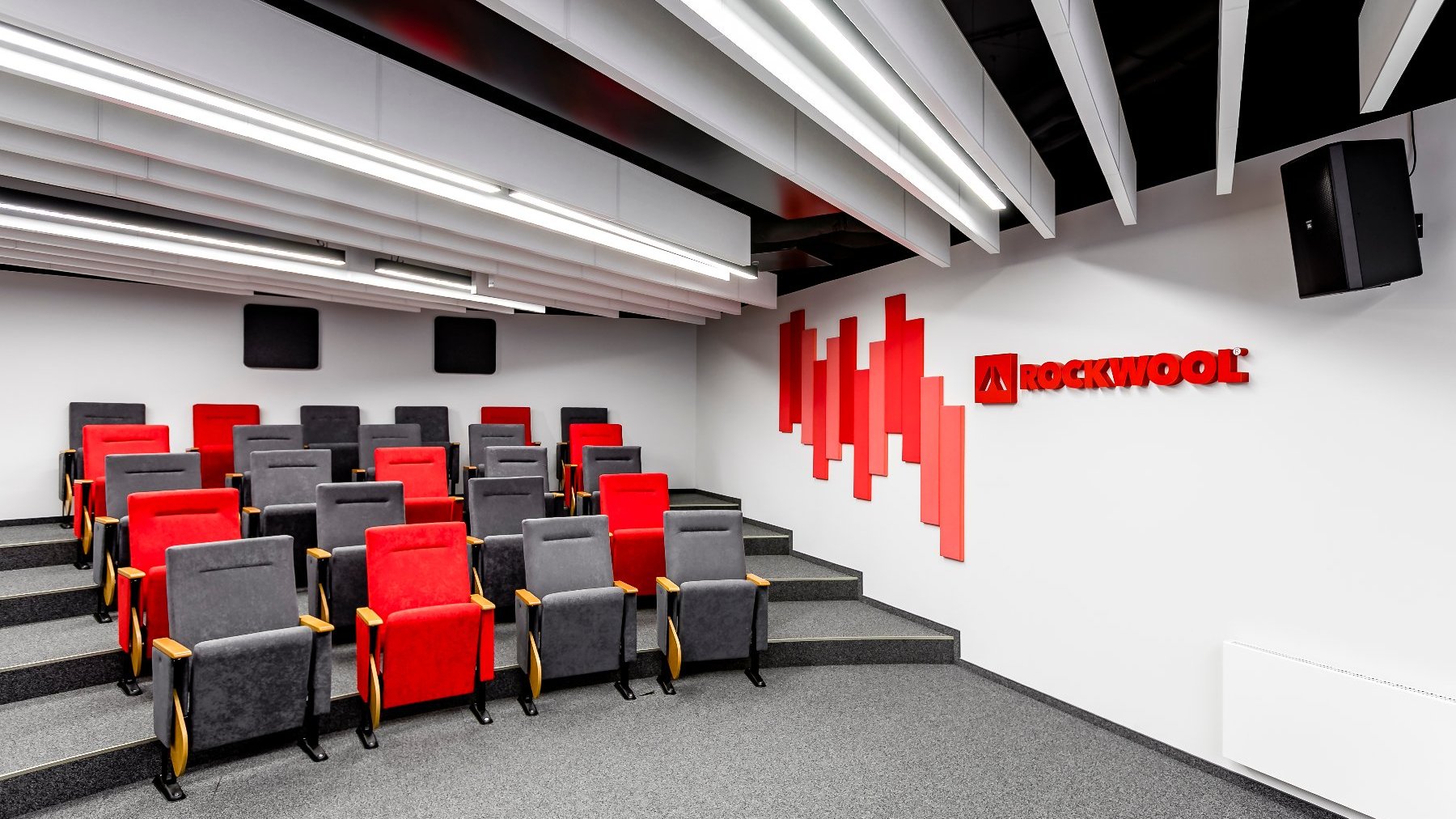 Conference room lined with grey carpet. ROCKWOOL logo on the wall.