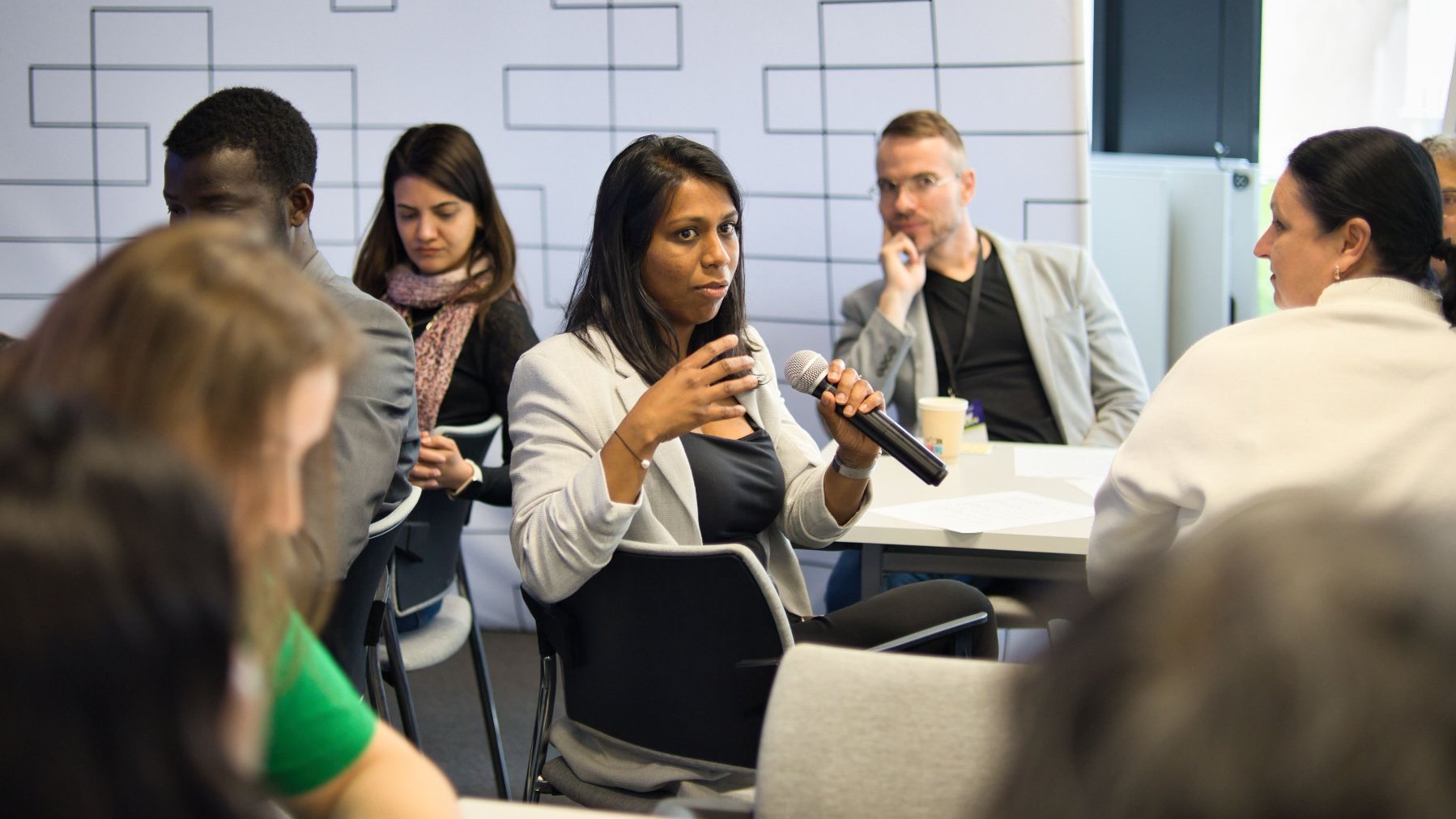 One of the participants of the networking workshop is speaking. The other participants can be seen around her.