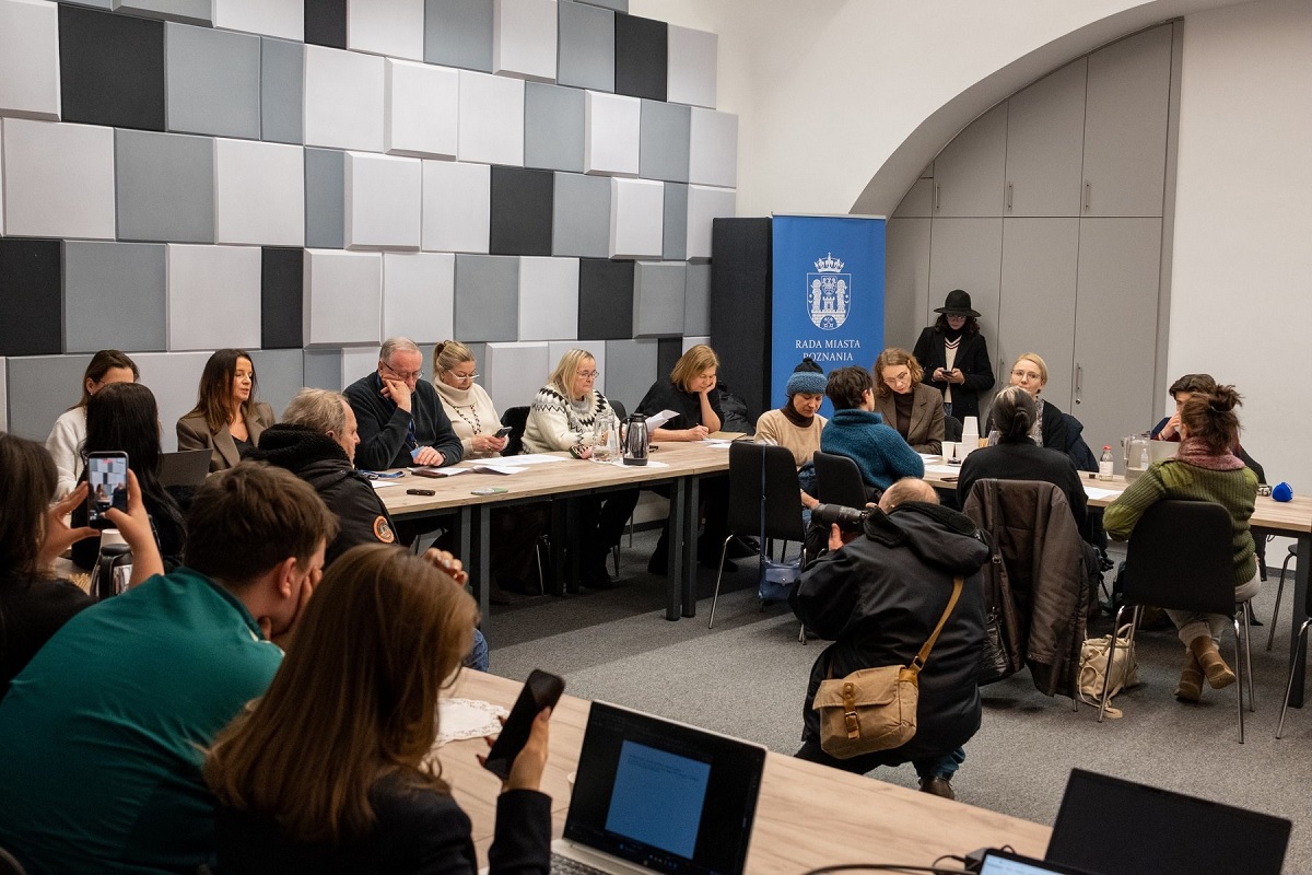 Co najmnie kilkanaściowo osób obraduje przy stole konferencyjnym w sali - grafika artykułu