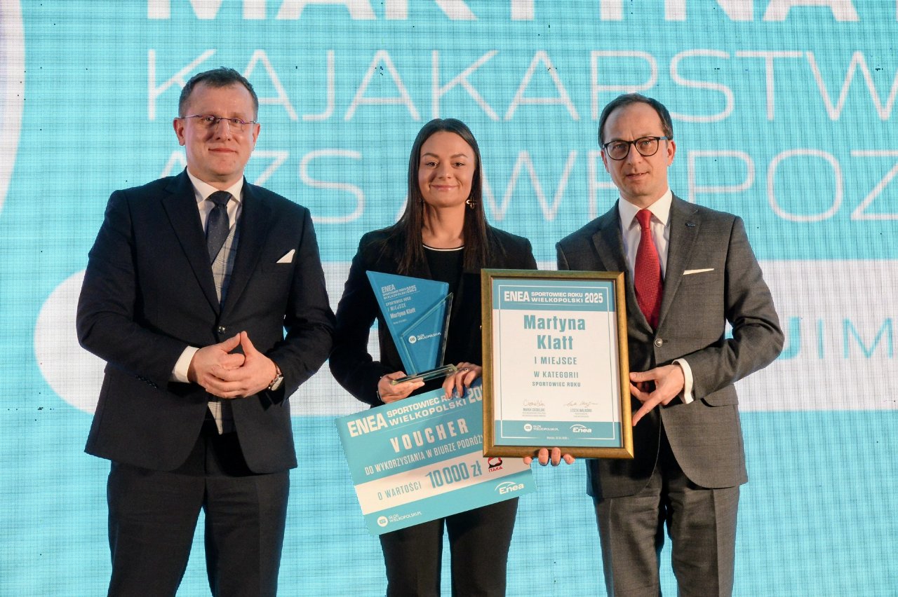 Gala Rankingu Enea Sportowiec Roku Wielkopolski 2025, fot. Robert Woźniak/Głos Wielkopolski - w środku elegancko ubrana kobieta, która trzyma statuetkę i dyplom, a po bokach mężczyźni w garniturach
