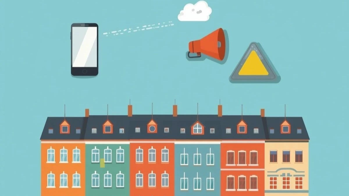 Grafika, kolorowe kamieniczki a nad nimi telefon komórkowy, żółty trójkąt oraz pomarańczowy megafon.