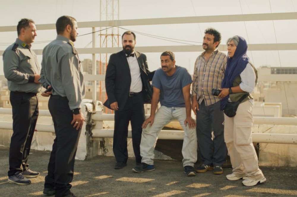 Grupa ludzi rozmawia z dwoma policjantami.