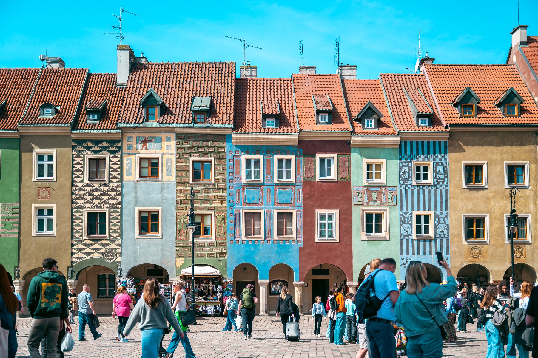 Na zdjęciu domki budnicze, przed nimi spacerujący ludzie