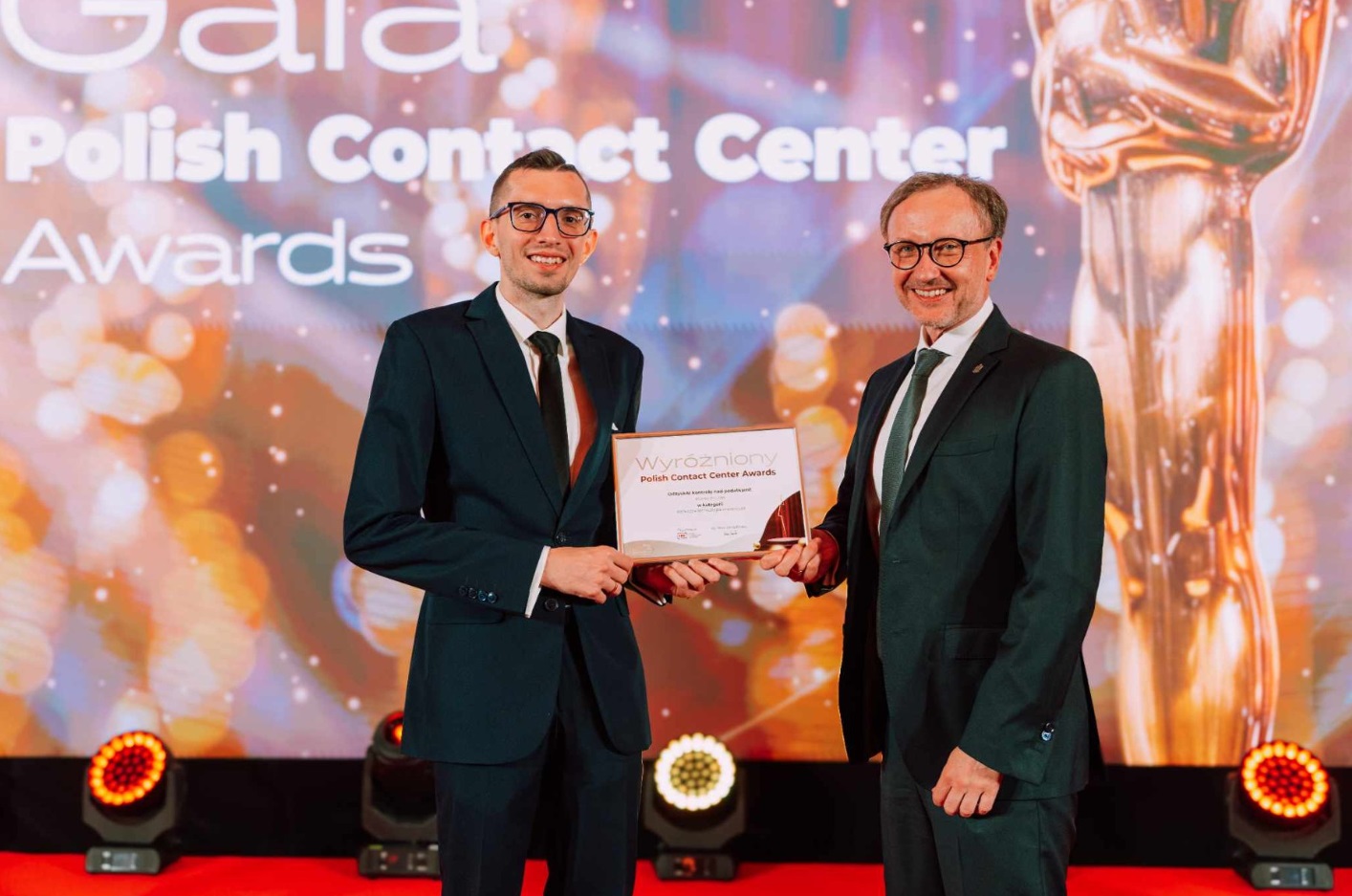 Podczas gali Urząd Miasta Poznania reprezentował Krzysztof Rogala, kierownik Oddziału Automatyzacji Procesów Teleinformacyjnych Poznań Kontakt Na zdjęciu dwóch mężczyzn trzymających wyróżnienie, w tle kolorowa ścianka