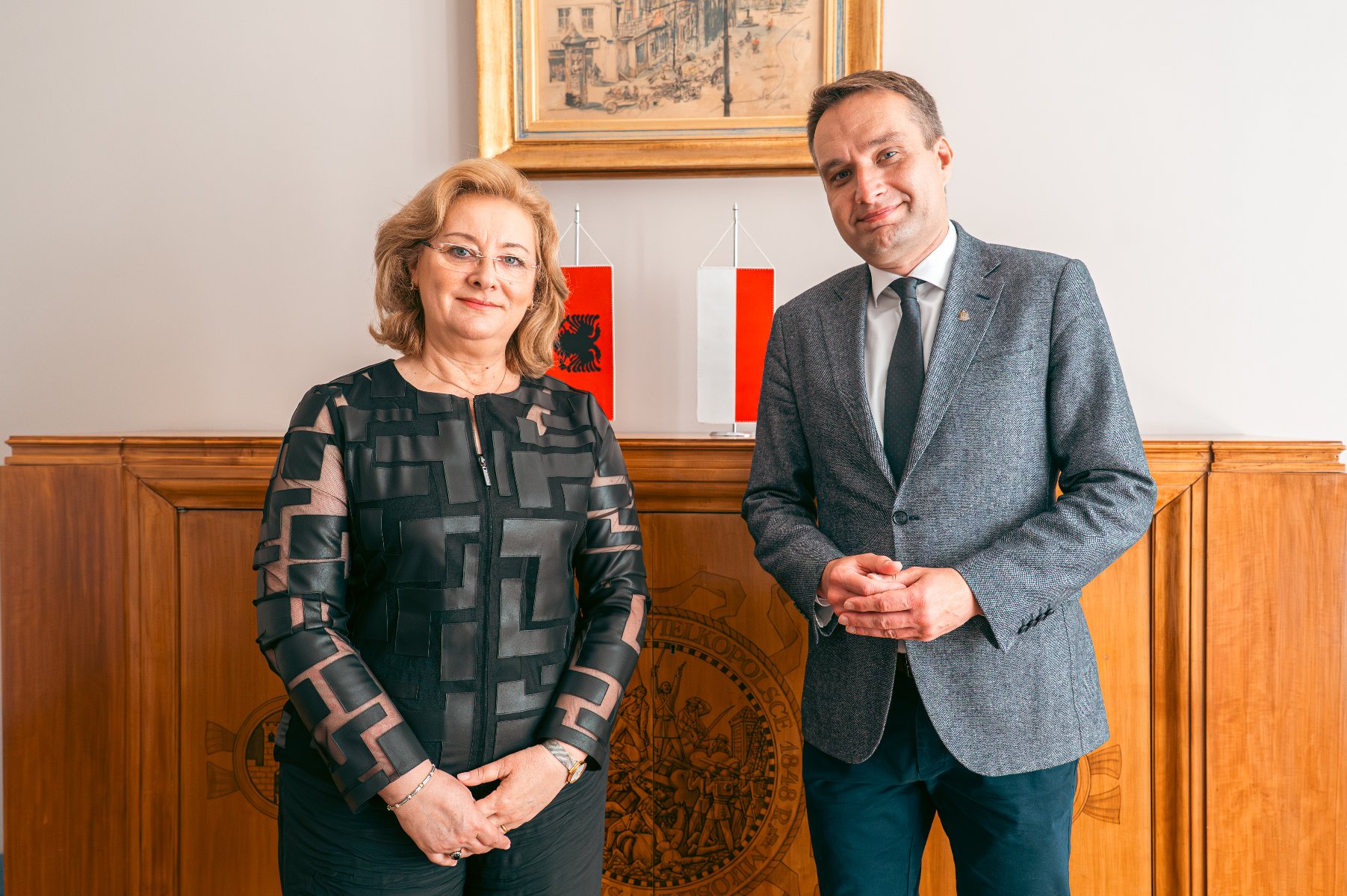 Na zdjęciu kilka osób przy stole, na wprost obiektywu siedzi kobieta o jasnych włosach