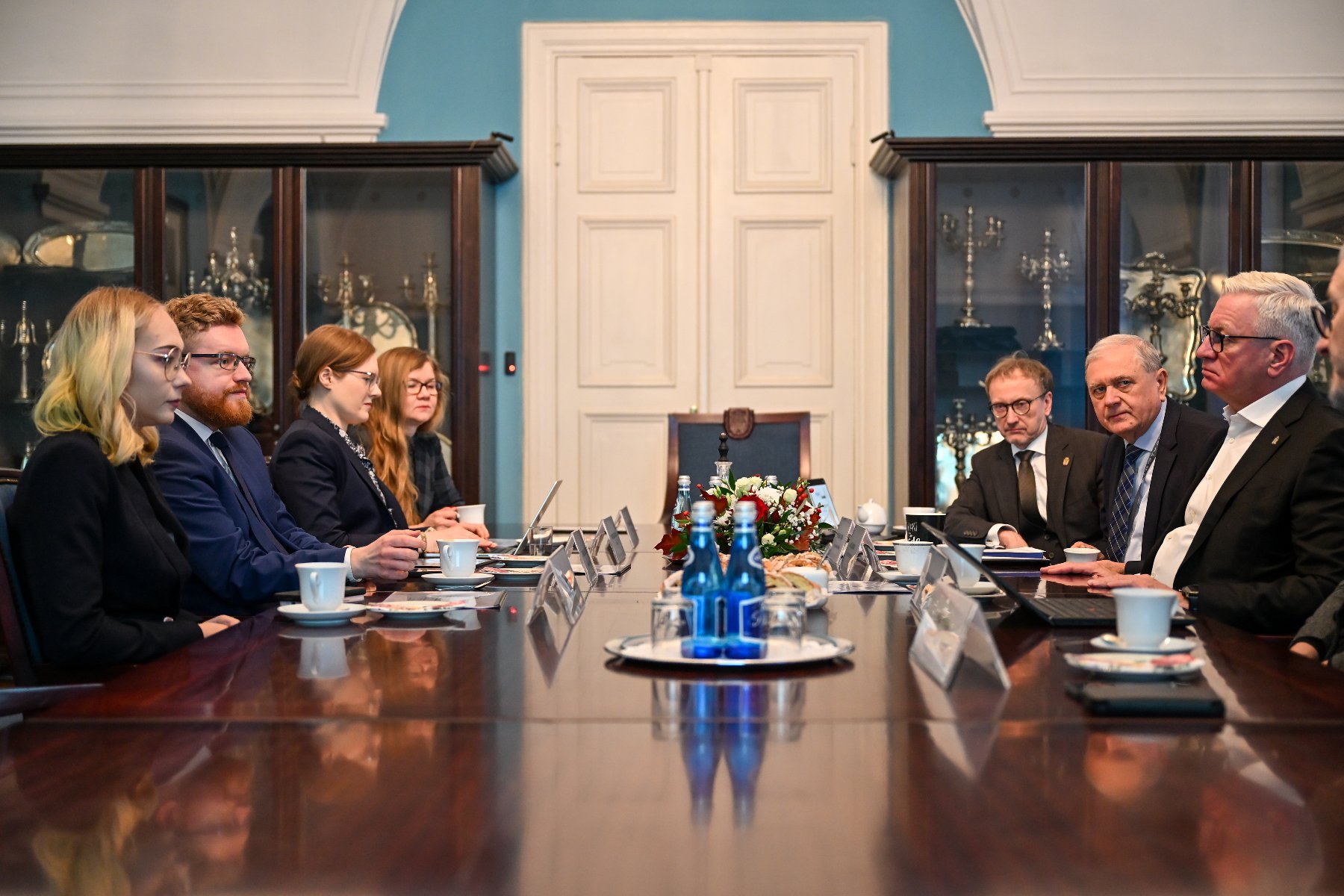 Na zdjęciu kilka osób siedzących przy dużym stole w reprezentacyjnej sali urzędu miasta