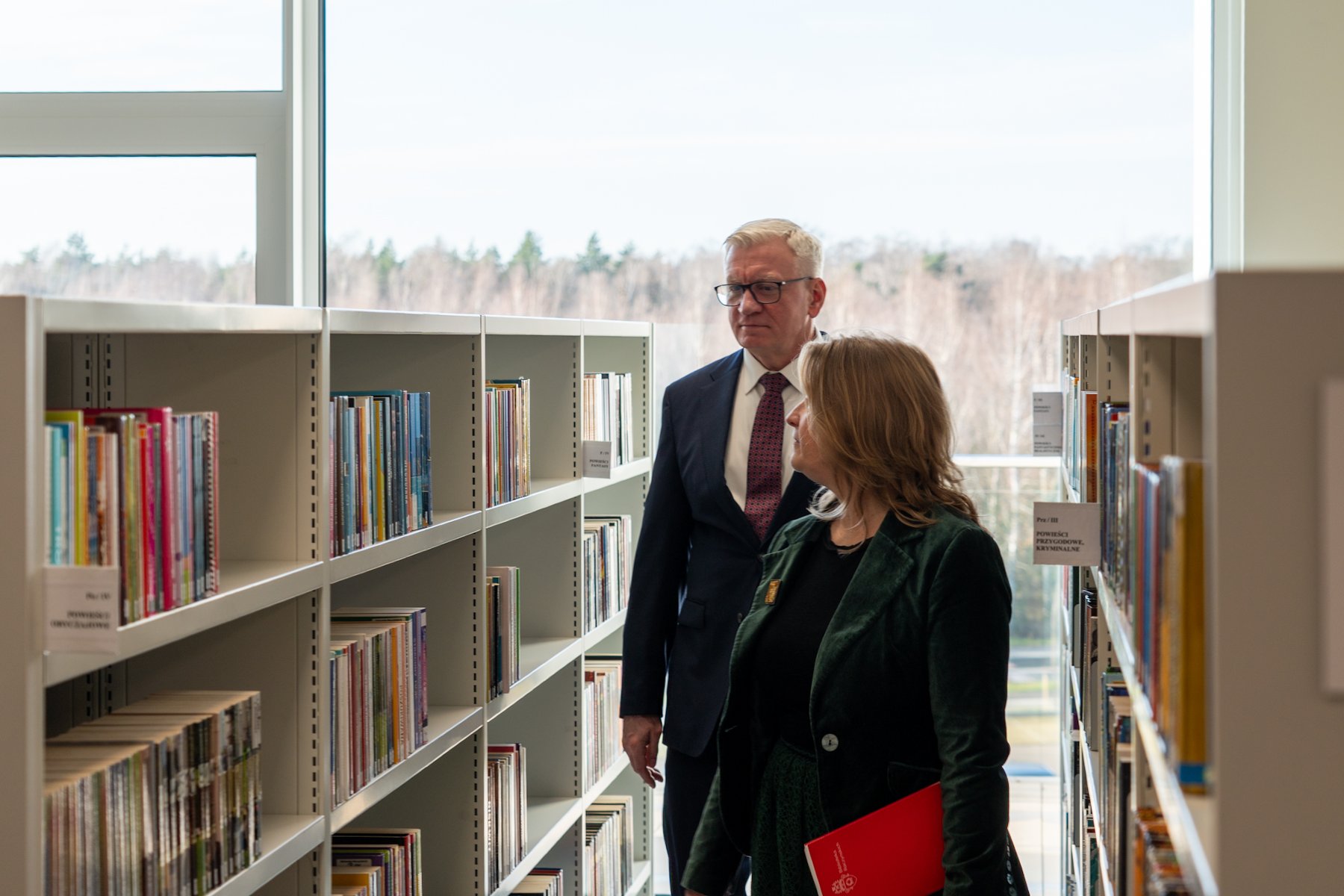 Na zdjęciu kobieta z dzieckiem wśród półek z książkami