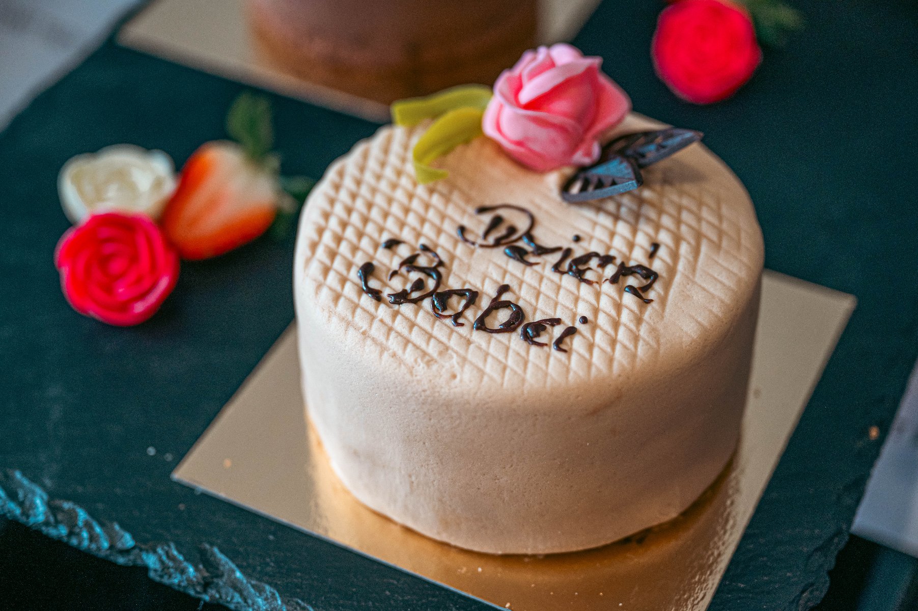 Na zdjęciu niewielki tort ozdobiony różą i napisem: Dzień Babci