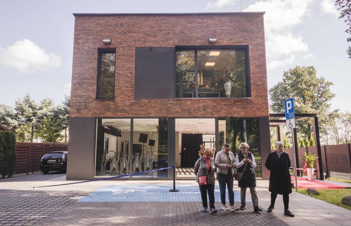 Nowoczesny budynek jednopiętrowy, przed nim ludzie